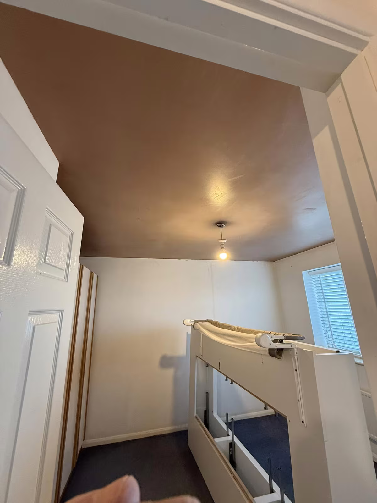 A landing with a new plastered ceiling and bulkhead over the stairwell